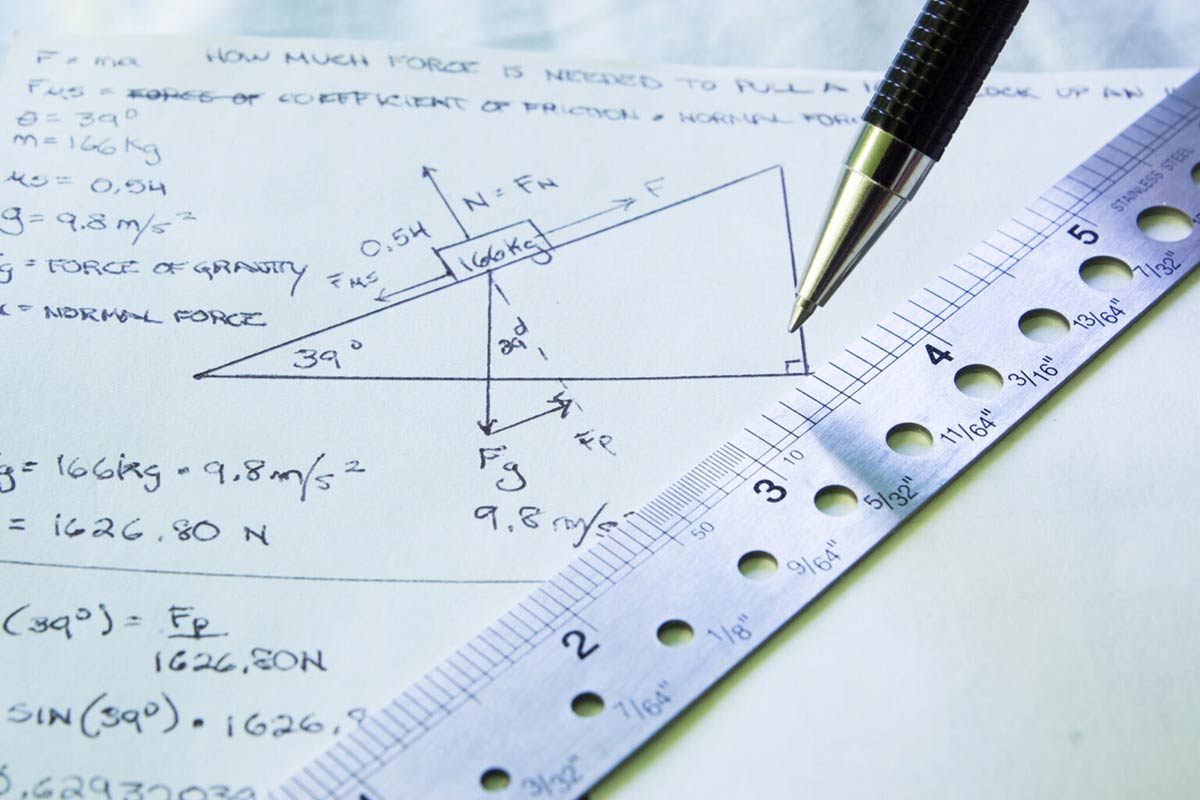 A pen and ruler on a piece of paper with calculations